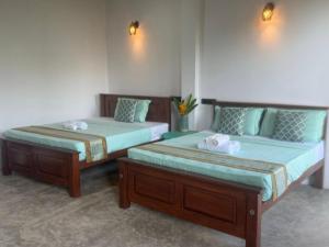 two beds sitting next to each other in a room at The wild culture in Sigiriya