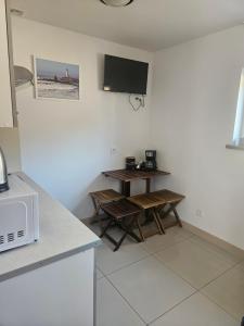 a kitchen with a table and a tv on the wall at Cichy Zakątek in Bobolin