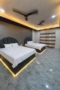 a room with two beds and chairs in it at Lari Guest House in Gorakhpur