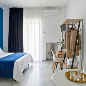 a bedroom with a bed and a desk and a table at Melo Accommodations in Bari