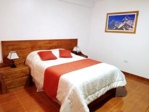 a bedroom with a bed and a picture on the wall at CASA TALIOS in Carhuaz