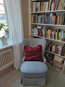 a chair with a pillow in front of a book shelf at Lilla Hotellet in Lund