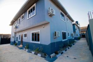 a blue building with potted plants in front of it at Living Space Apartment in Ibadan