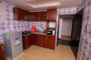 a kitchen with wooden cabinets and a stainless steel refrigerator at Living Space Apartment in Ibadan