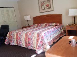 una camera d'albergo con letto e tavolo di Travelers Lodge ad Atco