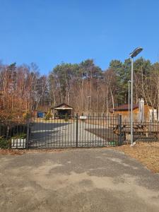 a fence in front of a park with a playground at Cichy Zakątek in Bobolin