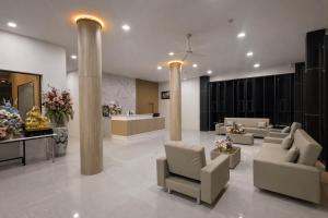 a lobby with couches and chairs and columns at โรงแรมแซนด์บอกซ์ นครศรีธรรมราช in Nakhon Si Thammarat