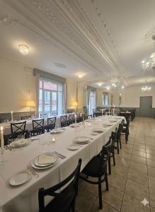 a large banquet hall with white tables and chairs at Hôtel Myosotis in Lourdes