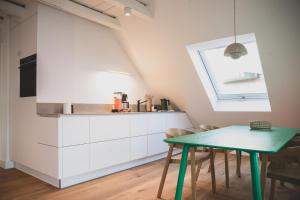 a kitchen with a green table and a window at Appartements Brigg & Schoner in Neuharlingersiel +115 photos