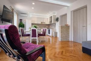 a kitchen and living room with a table and chairs at Apartments Karla in Stanići