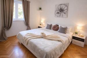 a bedroom with a large white bed with two lamps at Apartments Karla in Stanići