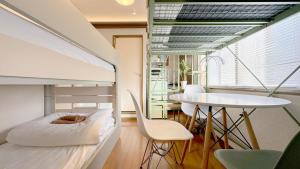a room with a bed and a table and chairs at JindaijiStudio SAZU222 in Chofu