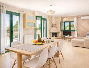 a dining room and living room with a table and chairs at Haroupia The Residence in Kalidhón