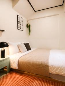 a bedroom with a bed and a desk with a lamp at Atelier7419 Songpa in Seoul