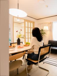 a woman sitting at a table in a living room at Atelier7419 Songpa in Seoul