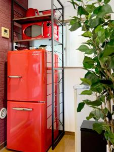 an old red refrigerator with a microwave on top at JindaijiStudio SAZU222 in Chofu