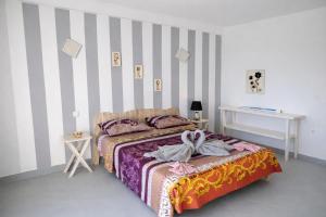 a bedroom with a bed and a striped wall at Pensão Big Game Maio Vila do Maio in Vila do Porto