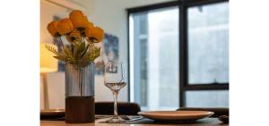 a table with a vase with yellow flowers and a glass at Luxe 46th Level 2 Bedroom CBD Apartment with Pool Gym Spa and Views in Melbourne +10 photos