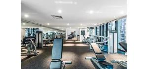 a gym with several treadmills and machines at Luxe 46th Level 2 Bedroom CBD Apartment with Pool Gym Spa and Views in Melbourne