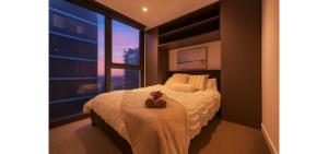 a bedroom with a bed and a large window at Luxe 46th Level 2 Bedroom CBD Apartment with Pool Gym Spa and Views in Melbourne