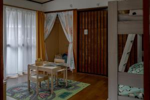 a room with a table and a bunk bed at 一棟貸しの宿 Granny and the sea グラニーアンドザシー in Shima