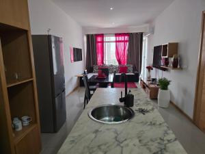a kitchen with a sink and a living room at My Flat 2 in Praia