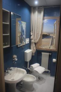 a blue bathroom with a toilet and a sink at Affittacamere la Tortuga in Portovenere