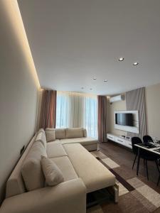 a living room with a couch and a flat screen tv at Rapo Apartment in Krujë