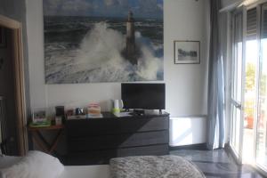 a bedroom with a dresser with a picture of a wave at Affittacamere la Tortuga in Portovenere +28 photos