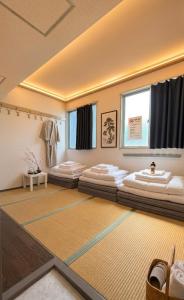 a room with four beds in it with a carpet at 心斎橋難波関空直通Nambaminami direct to Shinsaibashi Ambers Hostel in Osaka +31 photos