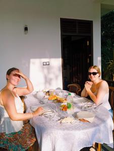 two women sitting at a table eating food at Moonlit serenity Tangalle in Tangalle