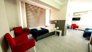 a room with a bed and two red chairs at Koc Hotel in Karasu
