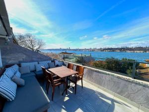 a balcony with a table and chairs and a view of the water at Kuzguncuk View in Istanbul