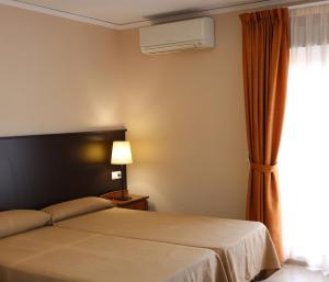 a hotel room with a bed and a window at Hotel Fin De Semana in Gandía