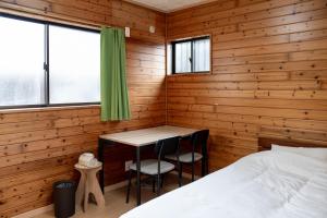 a bedroom with a bed and a desk in it at 一棟貸しの宿 Granny and the sea グラニーアンドザシー in Shima