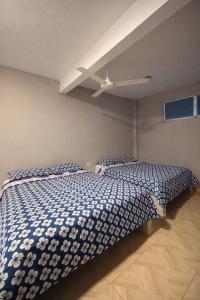a bedroom with a bed with a blue and white comforter at Hotel Palmera Beach in Cartagena de Indias