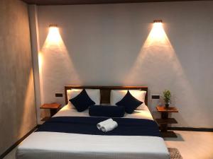 a bedroom with a bed with two lights on the wall at Ella 96TN Resort in Ella