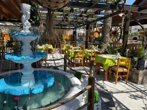 a fountain in the middle of a patio with tables and chairs at Lambi beach City Suite in Kos