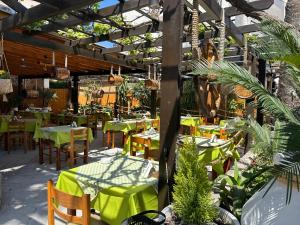 a restaurant with tables and chairs with green tables at Lambi beach City Suite in Kos
