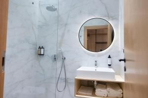 a bathroom with a sink and a shower with a mirror at Mece Hotel Tirana in Tirana +65 photos