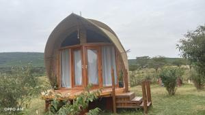 a small dome tent with a bench in a field at Hotel White Sandcastle Mara in Sekenani