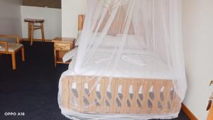 a bedroom with a bed with a mosquito net at Hotel White Sandcastle Mara in Sekenani