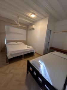a bedroom with two beds and a ceiling at Hotel Palmera Beach in Cartagena de Indias +2 photos