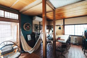 a living room with a hammock and a dining room at guesthouse TANDEM in Matsumoto