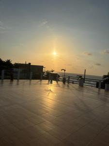 a sun setting over the ocean with a tiled sidewalk at Hotel Palmera Beach in Cartagena de Indias