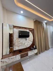 a living room with a flat screen tv on a wall at Hotel JP palace in Orchha +39 photos