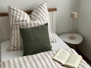 a bed with two pillows and a book on it at Ferienhaus Weidblick in Westerstede