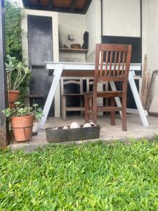 a wooden chair sitting on a patio with a table at Casa taller in Tigre