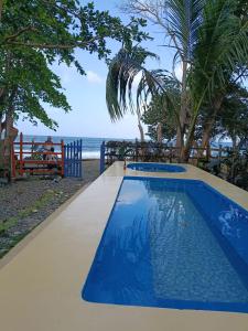 a swimming pool with a view of the ocean at Casa hostal playa coral in Capurganá