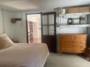 a bedroom with a bed and a wooden dresser at Casa taller in Tigre